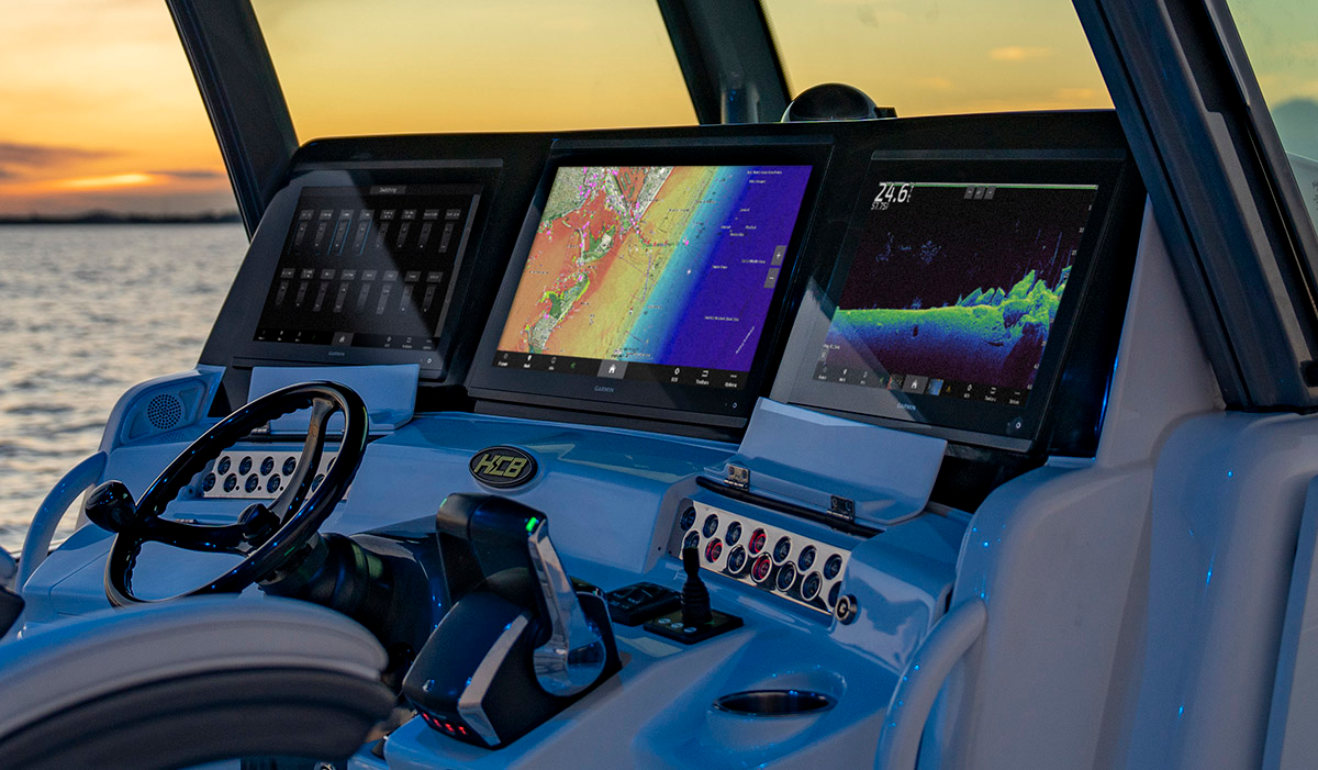 Argus helm at sunset with three Garmin displays showing switching, navigation and sonar